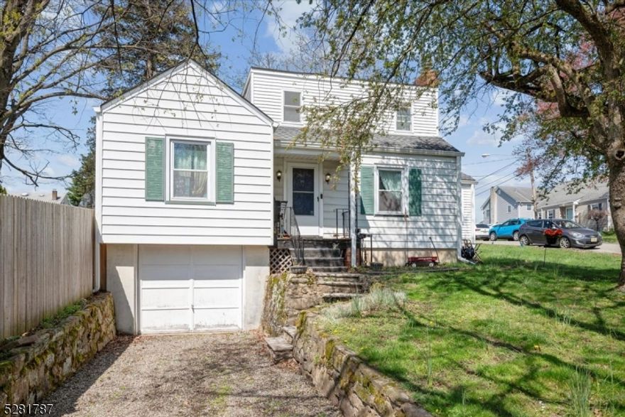 Spacious & Charming in an Excellent Location! This expanded Cape Cod home has over 1,700 sq ft of living space with 3 bedrooms, 2 full baths and attached 1-car garage set on a corner lot in a quiet residential neighborhood just blocks away from schools, with easy access to shopping, dining, parks, major highways and NYC direct train.. An inviting main level boasts wide-plank wood flooring and abundant sunlight, starting with a living room warmed by a cozy fireplace with stone surround and adjacent sunroom with rear entry. There's direct flow into a formal dining room with plenty of room to host everyone for dinner, and just beyond is an eat-in kitchen with crisp white cabinets, lots of counter space, and a breakfast nook tucked in front of a deep bay window. A private office/den and convenient main-floor bedroom are off the hall, serviced a full bathroom with tub. Upstairs you'll find two more bedrooms, including a huge primary with 2 Walk-in Closets for your storage needs, and a second full bath in the hall. The partially finished basement offers more living space, with two distinct rooms perfect for a rec room or playroom, plus more storage, utilities and laundry. Enjoy warm-weather cookouts in your fully fenced backyard with a sprawling lawn ready for gardening, relaxing, and playing games.