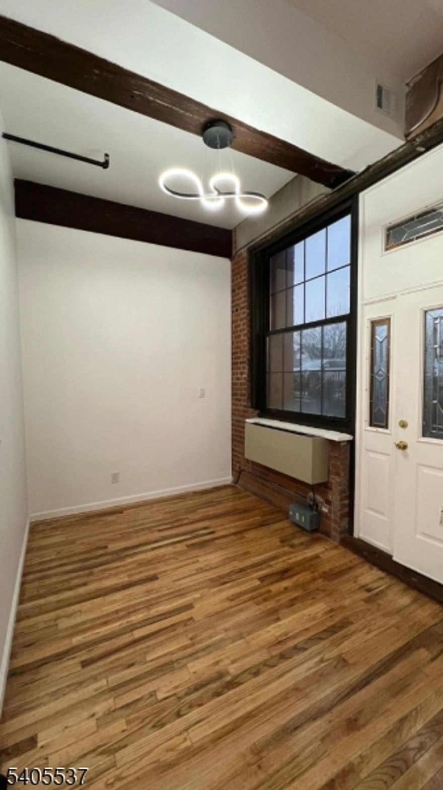 Experience elevated city living in this sun-filled loft-style residence with dramatic ceilings, exposed brick, and oversized windows that flood the space with natural light. The home has been completely refreshed with a sleek new kitchen, stainless steel appliances, and a modern spa-inspired bathroom. Featuring one bedroom plus a versatile interior den   perfect for working from home or accommodating guests. Enjoy the convenience of a private entrance, on-site laundry, pet-friendly living, and optional assigned parking.