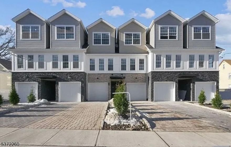 Discover modern living in this stunning end-unit townhome built in 2020. The ground floor offers a garage entrance, stackable laundry, a full bathroom, and a bedroom that opens to an outdoor patio. The second floor features a bright living room, an open-concept kitchen and dining area with sleek finishes, and a powder room. A private deck extends from this space, ideal for relaxing or entertaining. The third floor includes a spacious main bedroom with custom closet, a full bathroom, and another bedroom with its own custom closet. Located near Garfield train stations and NYC-bound buses, this home is perfect for commuters. Nearby parks, shopping, and dining complete the package, offering the perfect blend of style, comfort, and convenience. Don't miss this incredible opportunity!