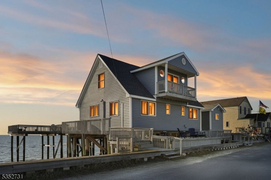 Completely renovated 5 bedroom, 4 bath custom luxury retreat on serene Delaware Bay. Enjoy coastal living at its finest with 100 ft of unobstructed bay frontage, your own private beach, a wrap-around deck perfect for entertaining, fishing, crabbing, and even under deck swings. Indulge in relaxing evenings with unbeatable sunsets and beach fires. The main home features an open concept modern floorplan with sliding doors opening up the entire back to the expansive deck, two primary en-suites each complete with their own private deck, two additional large bedrooms and another full bath. The separate guest house suite features a large light filled bedroom also opening to the wrap around deck, full bath and additional storage. From discovering Cape May diamonds to marveling at spring's ancient horseshoe crab migration, this refined escape truly embodies a location where nature's beauty meets effortless tranquility. Walk or bike to nearby Reeds beach and multiple wineries. Easy access to coffee shops, restaurants, shopping and marinas. Home also has profitable vacation rental history perfect for investors.