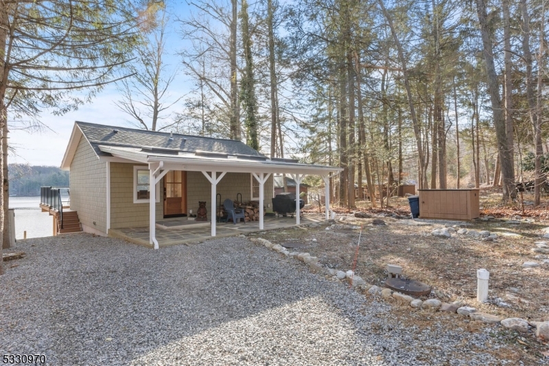 Welcome to your dream LAKEFRONT retreat on Lake Owassa! This charming, fully renovated and remodeled property offers an open concept design that is both light + bright, with numerous windows that provide incredible water views. Imagine waking up to a breathtaking SUNRISE from the home or walk down the gravel path to the lake where you'll find a second deck + floating dock. This delightful FULLY FURNISHED (inc. all contents!) home features 2 cozy bedrooms and 1 beautifully appointed bathroom. The kitchen is a true showstopper, with no detail overlooked. It boasts stunning sleek countertops, modern gold hardware, island that seats five w/extra storage cabinets, neutral backsplash and SS appliances. Slider door offers direct access to a deck with glass panels, ensuring your view is never compromised. The family room is a perfect gathering space, featuring an oversized picture window and a wood-burning stove, ideal for those chilly nights. The stackable W/D, mechanicals, sink and water softener are located in the basement storage room, accessible via exterior door. This property is not just a home; it's a lifestyle. Convenient to Appalachian Trail and Stokes State Forest too. Motorboats allowed. Lot across street INCLUDED. Enjoy the tranquility of lakefront living with all the modern comforts and stunning design elements. Don't miss the opportunity to make this lakefront gem your own! Community allows short term rentals - property is turn key!