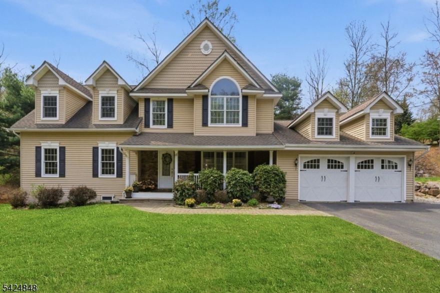 Welcome to this custom Colonial home loaded with amenities, located just moments from the Lake Valhalla Clubhouse. A covered rocking chair front porch & excellent curb appeal set the tone, with the home set back from the road for added privacy. Inside, a dramatic vaulted great room addition with natural stone fireplace & oversized windows brings in exceptional light, enhanced by extra lighting throughout the interior & exterior. The great room flows into an open concept kitchen with center island, ample cabinetry + generous prep space, all overlooking the expansive private backyard & wood deck. Upstairs are 2 primary bedrooms. The main primary suite features a clawfoot style soaking tub, separate shower, marble top vanity, huge walk-in closet, &  large loft space ideal for an office, library, or exercise area. The 2nd primary bedroom features a huge walk-in closet/storage area. An additional full bath is located in the hallway. Both bedrooms offer flexibility and room for work areas. In addition, there are three bedrooms on the first floor. Formal living & dining rooms with hardwood flooring provide excellent entertaining space. 1st  floor laundry adds convenience. A huge finished basement offers exceptional space for recreation, media, or hobbies. Additional highlights include an oversized 2 car garage with refrigerator included, whole house generator, all public utilities, and extensive lighting inside and out. A rare opportunity in the Lake Valhalla section of Montville.