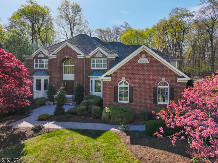 Experience 5,100+ square feet of refined living in this stunning, brick-front colonial with a 3-car garage located in the coveted Beacon Crest section of The Hills.This 5-bedroom, 4.2 bath residence combines classic architecture with timeless modern updates.Hardwood floors guide you through a thoughtfully designed layout both for everyday living and formal entertaining. Enjoy abundant light from the two-story family room with gas fireplace and statement millwork. The custom designed, sun-drenched kitchen features inlaid cabinetry, travertine floors, granite counters and professional-grade appliances. A bead board ceiling adds character to the sunroom, while the columned, two-story family room with extensive millwork provides an abundance of natural light. The butler's pantry offers exceptional functionality with wine tower, bar sink, and dishwasher. Stunning office w/ adjacent half bath offers a first-floor bedroom option. Upstairs, the luxurious primary suite features: stunning millwork, sitting area, walk-in closets, and spa-quality en suite bath. Four additional bedrooms (one currently serving as a theater room) feature Jack-n-Jill baths. The expansive walkout finished basement offers versatile spaces -studio, exercise room, game or rec room. Endless outdoor enjoyment abounds in the private backyard with custom-designed maintenance free deck and sports/movie night wall. Additional highlights include a newer roof, whole-house generator, and attached storage shed.