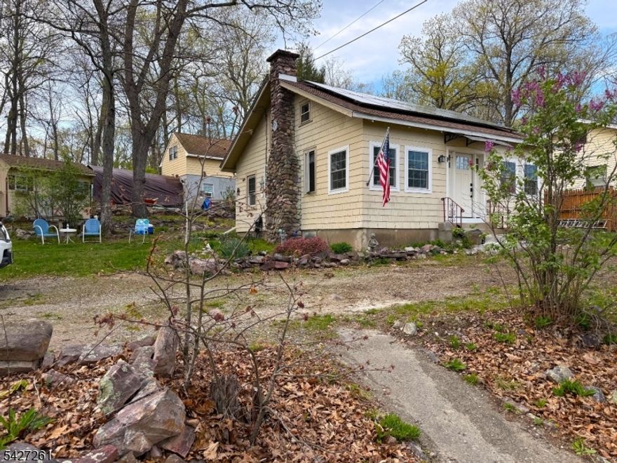 Adorable Cottage-Style home on large private lot, with separate, adjoing additional .8 acre lot included...Total property amounts to 1.2 acres. Don't miss this opportunity to own this home and add your personal touches to make your dream getaway. This 2 bedroom 1 bath home has a fireplace, a newer roof with solar panels, a state of the art on-demand water heater, enclosed 3-season porch, passing septic, and detached garage with a worksop space. The walk-up 2nd floor of the garage offers unlimited possibilities. Close to Greenwood Lake, shopping, parks, Warwick restaurants, the drive-in, and the NYC commuter bus stops right down the street.