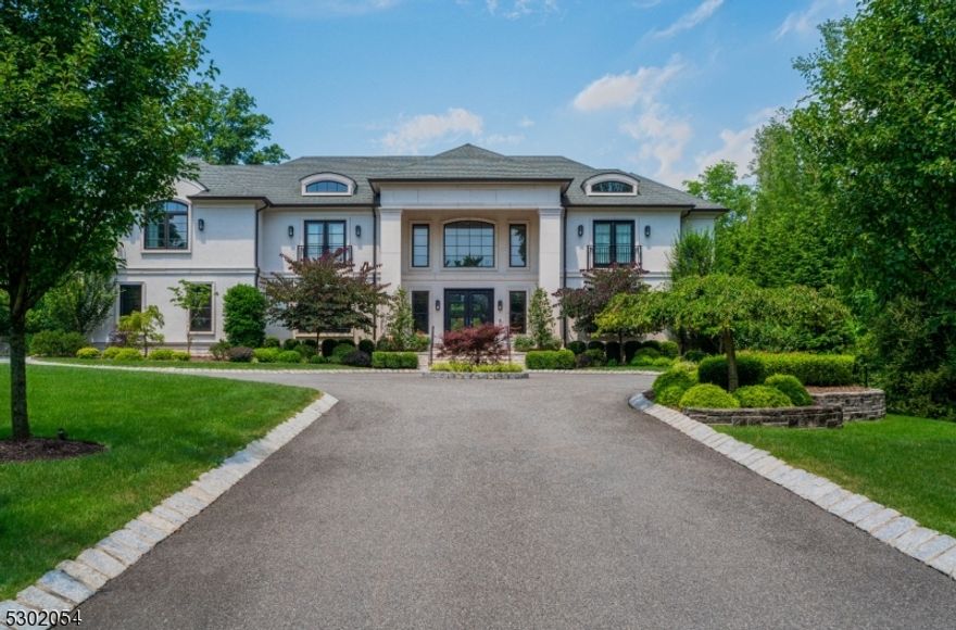 Set on a lush 1.822 acres, one of the largest and most private estates in all of Short Hills, this residence embodies both modern elegance and sophistication. As you wind up the long drive, the impressive landscaping and sizable acreage create an immediate sense of bespoke luxury. Upon entering, a stunning curved staircase serves as the home's centerpiece, complimented by an exquisite custom chandelier that warmly illuminates the space. The great room, with its double height and floor-to-ceiling windows, offers stunning views of the meticulously landscaped rear grounds and pool, creating a seamless indoor-outdoor living experience. The gourmet kitchen features sleek cabinetry, state-of-the-art appliances, two spacious islands and a walk-in pantry. On the second level, the primary suite is a sanctuary of comfort, featuring an entry vestibule, private balcony, radiantly heating flooring, gas fireplace and exquisite closets reminiscent of the finest boutiques. The walk-out lower level is expansive, with two recreation areas, exercise room, bedroom suite, several storage rooms and a bonus space -- an ideal future theater or golf simulator. Outside is an entertainer's dream, boasting a new pickleball/multi-sports court, resort-style pool, inviting fire pit, covered patio with retractable screens, changing room/full bath, fully equipped outdoor kitchen and sprawling manicured lawns. This residence reflects meticulous attention to detail, offering unparalleled luxury and comfort.