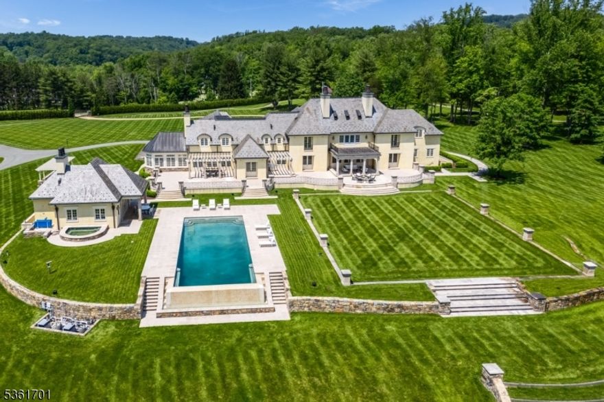 Discover the pinnacle of luxury living in this exquisite 6-bedroom French country estate, set on 11 unparalleled acres. Designed by Brandes Maselli and completed in '08, this architectural masterpiece underwent contemporary updates in 2023. Through a gated entry and winding drive, you will be greeted by the residence's stately stucco and slate facade. Step inside to a world of refined luxury, where custom architectural millwork, rich hardwood floors and limestone fireplaces elevate every space. The gourmet kitchen is a culinary masterpiece, perfectly situated to flow into light-filled living and dining spaces with custom mahogany French windows and doors. The 2nd level features a large in-law suite with private entrance. A fully finished lower level invites recreation and relaxation. The property's outdoor amenities rival those of a luxury resort with an expansive limestone patio, infinity-edge pool,  spa, and notable pool house. A lighted sports court provides tennis and basketball, while a perimeter walking path winds through the landscape. The cottage features a kitchen/living room, bathroom and garage. The rear yard is designed for large-scale tented gatherings/events. Your peace of mind is secured by an automatic generator, irrigation, security system and zoned sound system. This extraordinary estate allows privacy while enjoying proximity to award-winning schools, equestrian facilities, world-class golf courses, upscale shopping and dining, highways and NJ Transit.