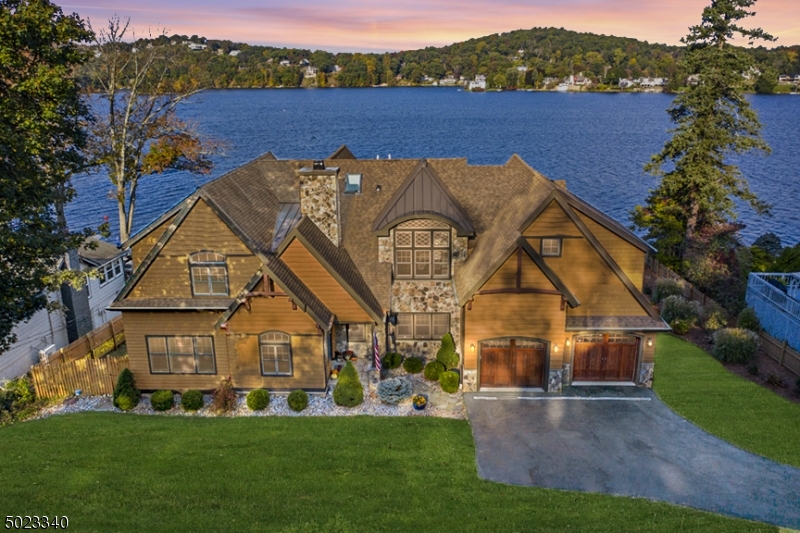 This gorgeous Lake Mohawk home has everything you could need!  Lakefront living at its finest.  Front row seats for the fireworks here, along with boat dock, original boathouse, and backyard beach. You will be impressed from the moment you enter this home. Stunning, original Lake Mohawk Crane log room, gourmet kitchen, formal dining room, open and light great room, sunroom, luxury master suite, 3 additional large bedrooms and office. The luxury custom finished basement was designed for entertaining, and also includes a gym and full bath. Tons of storage in the custom built-ins found throughout the home! A two car attached garage and additional parking. Location is perfect - close to the Lake Mohawk boardwalk and town, yet set back from the road and very quiet. Walk to everything, including the bus to NYC!