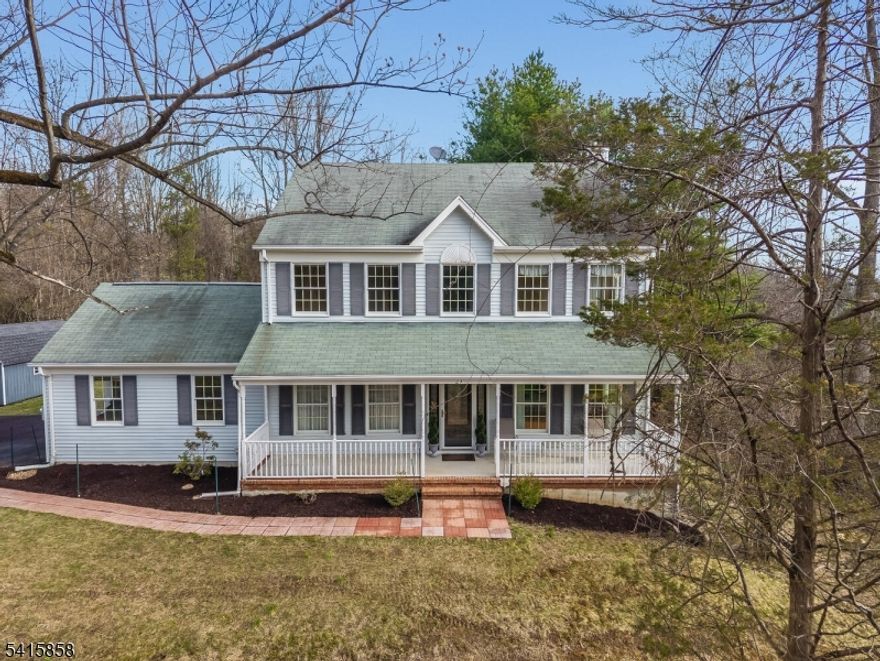 A 4BR & 2-1/2 BATH COLONIAL WITH SWEEPING LONG-DISTANCE VIEWS FROM A PRIVATE  HILLTOP SETTING ON A GORGEOUSLY LANDSCAPED 3.38 ACRE WOODED LOT IN A  LOVELY NEIGHBORHOOD OF COMPARABLE HOMES WITH A GREAT LOCATION LESS THAN 20 MINUTES FROM RT 78 OR AN EXPRESS BUS TO NEW YORK CITY. THIS WARM-AND-INVITING HOME FEATURES A GREAT OPEN FLOOR PLAN WITH A LARGE CENTER ISLE KITCHEN WITH GRANITE COUNTERTOPS AND WHITE CABINETRY. THE WIDE-OPEN ADJACENT FAMILY RM OFFERS A WOOD-BURNING BRICK HEARTH FIREPLACE FRAMED ON EITHER SIDE BY VIEW-FACING WINDOWS, AND A SET OF DOUBLE FRENCH DOORS WHICH LEAD TO A  LARGE, LIGHT, BRIGHT, & AIRY LIVING ROOM/OFFICE COMPLETE WITH HARDWOOD FLOORS AND A BIG PICTURE WINDOW OFFERING GREAT VIEWS OF THE DISTANT MOUNTAINS. OTHER HIGHLIGHTS INCLUDE A WELCOMING TWO-STORY FOYER AND AN ATTRACTIVE FORMAL DINING RM WHICH ALSO HAS HARDWOOD FLOORS AND INTRICATELY-DETAILED DECORATIVE MOLDINGS INCLUDING SHADOW-BOXES, CROWN-AND-DENTIL, AND A DECORATIVE CEILING MEDALLION FROM WHICH THE CHANDELIER IS SUSPENDED. THE SECOND FLOOR FEATURES AN EXPANSIVE MASTER BEDROOM SUITE WITH A 10FT HIGH TRAY CEILING AND A LARGE WALK-IN CLOSET, A LUXURIOUS SKY-LIGHTED MASTER BATH WITH A WHIRLPOOL TUB AND PRIVATE SHOWER, SPACIOUS SECONDARY BEDROOMS, A CONVENIENT SECOND FLOOR LAUNDRY RM, AND A FRESHLY-PAINTED SHARED HALL BATH WITH A NEW DOUBLE VANITY TOP. OTHER ASPECTS OF NOTE INCLUDE A  SHADE-PROVIDING ROOFED FRONT PORCH, AN OVER-SIZED PATIO OVERLOOKINGA TOTALLY PRIVATE BACKYARD, & A NEW WELL PUMP