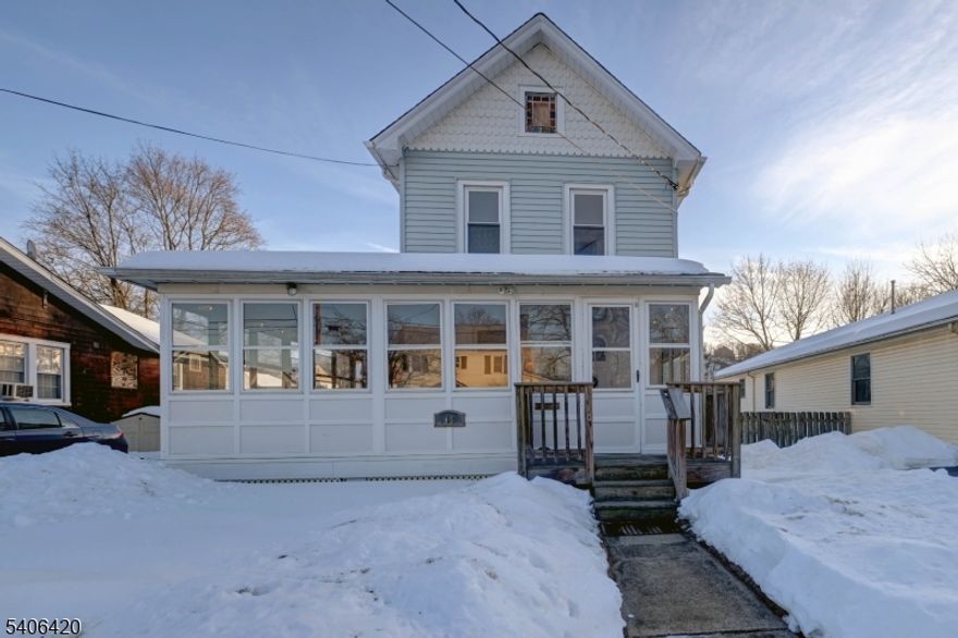 Sun-filled, enclosed wrap-around porch welcomes you to this lovely Colonial located in the heart of Bloomingdale. This home offers a bright eat-in kitchen and a spacious dining room, perfect for gatherings and holiday dinners. The living room is adjacent to the dining room, creating an easy and inviting flow throughout the main level.The first floor features a versatile multi-use den, ideal as a home office, guest room, or additional bedroom. There is a half-bath located on the first floor for convenience. The second floor offers three nicely sized bedrooms and a main full bath.Step outside to a beautiful, new 6' vinyl fenced-in backyard with a deck  perfect for relaxing and enjoying sun-filled evenings. Take advantage of the wonderful location, close to major highways, shopping, NYC transportation, and local shops just a short distance away.Sidewalk and street are brand new. Seller will payoff the balance of the sidewalk assessment at closing.Don't miss this opportunity to own a great home in the charming town of Bloomingdale!