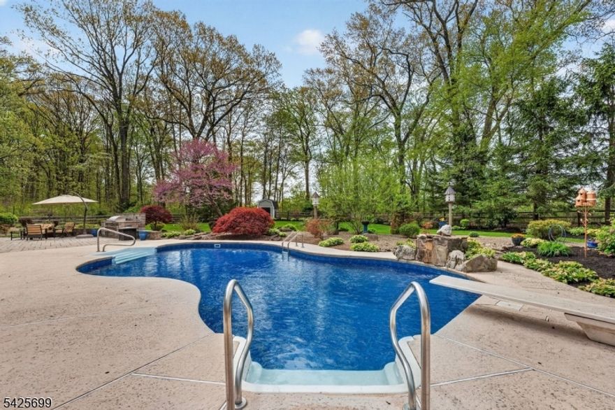 Set on 1.73 private acres backing to Fiddler's Elbow Country Club, one of the area's most desirable golf course communities, this custom Colonial blends timeless craftsmanship with thoughtful updates and resort-style living. Offering four bedrooms, two full and two half baths, the home showcases extensive custom millwork, built-ins, a wet bar, and refined architectural detail throughout. The chef's kitchen features radiant heated travertine floors, high-end custom cabinetry, center island, pantry, Liebherr refrigerator, and instant hot water. The primary suite offers a cathedral ceiling, custom closets, new skylights, and a beautifully appointed bath with jetted tub and stall shower. Major improvements include a new roof (2023), new generator (2020), new heat pump in the primary bedroom (2021), new pool heater (2020), new hot water heater (2025), and updated sump pump. The finished lower level adds flexible living space and a private office. Outdoors, enjoy a saltwater pool and spa with new pump and liner (2025/2026), expansive patio, outdoor kitchen, irrigation from a dedicated well, and full deer fencing. A rare opportunity to own a meticulously maintained home backing to Fiddler's Elbow Country Club offering refined living and privacy.