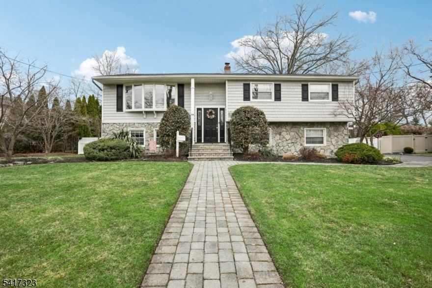 Set on a beautiful and expansive level property, this home offers an impressive open floor plan and is located in a highly desirable neighborhood?Welcome Home! Features include: Stunning layout with cathedral ceilings, a formal living room with a custom gas fireplace leading to the formal dining room, and an updated kitchen with a center island, granite countertops, tile backsplash, and stainless-steel appliances, plus a slider to the large deck. Primary bedroom is very bright and has private access to an updated full bathroom with double sinks and designer details. Two other bedrooms complete the main level of this home. Lower level includes: Large family room with a bay window and access to the paver patio. Another large bedroom includes a closet, access to a storage area, a laundry room, and a full bathroom. Additional attributes include: wonderful curb appeal, recessed lighting, an oversized two-car garage, many windows providing natural light, perfect for entertaining and beautiful hardwood floors. Enjoy the outdoors: Beautiful, large, level, park-like property with professional landscaping, fence, large deck, paver patios, walkways, and a huge, level backyard. Great location: top rated schools, Minutes to: restaurants, shopping, Whole Foods, Trader Joe's,  NJ transit bus and train center, community events and town library.