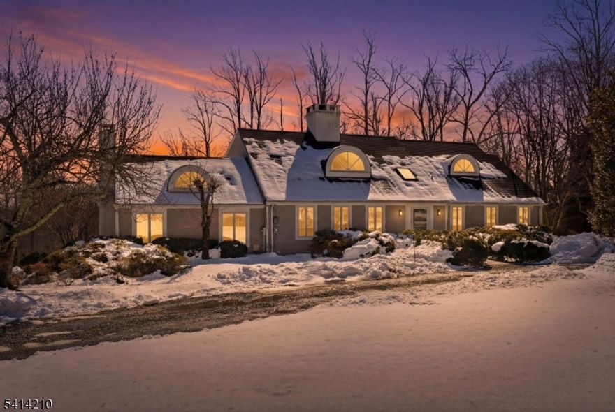 Set on 3.9 picturesque acres with a private pond in sought-after Harding Township, this beautifully renovated custom home blends timeless character with thoughtful modern updates. Five bedrooms, five full baths and three wood-burning fireplaces create exceptional flexibility across three finished levels. The expansive eat-in kitchen serves as the heart of the home, featuring a huge center island, multiple cooking stations (including indoor grill), pantry, and a generous dining area are ideal for both everyday living and entertaining. Formal Living and Dining Rooms offer classic appeal, highlighted by custom inset bookshelves in the Living Room. A spacious Family Room and walkout lower-level recreation room provide additional inviting spaces for gathering and possible in-law setup. The second-level primary suite provides a private oasis with a secluded deck overlooking the backyard. Two additional bedrooms are located on the second level, while a first-floor bedroom offers added dynamic living space. A three-car attached garage (with level 2 electric charging station), circular driveway, multi-zone heating and cooling, built-in generator, and serene open grounds with large garden enhance both comfort and functionality. This peaceful, estate-like setting is just minutes from Morristown, Basking Ridge/Bernardsville, dining, shopping, and commuter routes. An exceptional opportunity to own a refined Harding Township property!