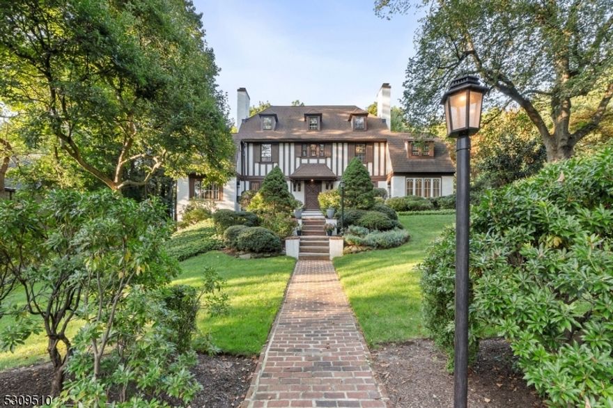 Discover a rare gem in the heart of Old Short Hills! Stunning 1911 English Tudor that blends historic charm w/contemporary comforts. Nestled on 1.03 acres of meticulously landscaped grounds, this stunning residence perfectly balances grandeur and livability. The front-to-back foyer and grand staircase sets the tone for the home's remarkable craftsmanship. Five fireplaces, an oak-paneled library, and newly refinished hardwood floors throughout showcase the home's impeccable attention to detail. The heart of this home is its state-of-the-art kitchen, featuring custom cabinetry, top-of-the-line appliances (Wolf, Sub-Zero, Bosch), a center island w/granite counters and the adjacent breakfast room w/built-in banquette. Upstairs, 5 bedrooms await, including a spacious primary suite w/spa-like bath. The lower level has a large rec room, bdrm 6, full bath, and laundry rm. Embrace outdoor living on the large brick patio, surrounded by lush gardens and open lawns. A bonus space above the garage provides flexibility for a home office, gym, or creative studio. Modern amenities ensure year-round comfort: central A/C, underground sprinklers, outdoor lantern lighting, and a generator for peace of mind, while the spacious grounds offer room for a pool. Located just blocks from top-rated schools and the Short Hills train station, this home offers convenience without compromising on privacy. Experience the perfect fusion of historic pedigree and modern luxury in this Old Short Hills treasure.