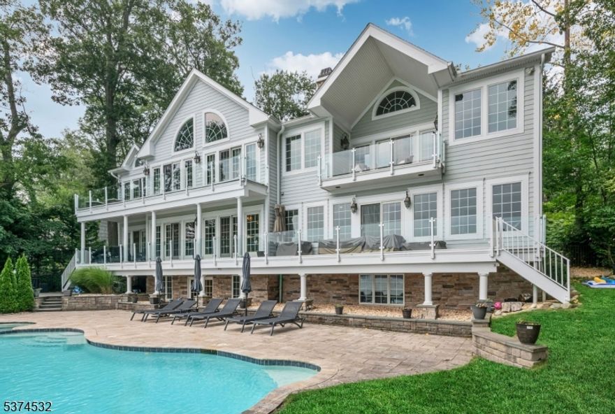 Fall in love with life on the lake at this breathtaking 5,430 SF home with additional walkout lower level space! A Colonial masterpiece set on prime property in Pines Lake. Custom built by original owner & renovated by current owner, this beautiful home was designed to capture the beauty of its surroundings, with sweeping water views from nearly every room & elegant architectural details throughout. A winding circular drive sets the stage, welcoming you to where charm meets grandeur. Step inside to a soaring entry with dramatic staircase & large foyer that opens to the main gathering area boasting a fireplace &  full wall of windows that witness the ever-changing canvas of lake & sky. An added bonus is the convenient newer 1st floor bedroom & full bath! Whether hosting friends beneath the stars or savoring quiet morning coffee by the water, the outdoor spaces are pure magic. Enjoy the sparkling gunite pool with spa, paver patio, & direct access to the shimmering lake beyond. Inside, every bedroom is a private retreat, including the dreamy primary suite with dual walk-in closets & mesmerizing water views. The home also features a theater room &  game room/ rec room for easy entertaining & peaceful everyday living the Pines Lake community, with boating, tennis, pickleball, social events, & lake privileges offer a resort-like lifestyle year-round! 3 car garage. Come live your storybook life on the lake where every sunset paints a new memory, every day feels like a getaway.