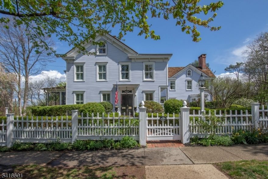 The historic village of Basking Ridge has welcomed residents since before the Revolutionary War, offering a charming Main Street, New England-style Colonial homes, and enduring farmsteads that define one of New Jersey's most appealing communities.This extensively renovated Circa 1872 home with 4 fireplaces is set on just under an acre. Rebuilt and expanded with exceptional craftsmanship by Scandic Builders, the home blends historic character with an upscale lifestyle. A primary suite with cathedral ceiling, dual walk-in closets, a balcony with distant seasonal views to skyline lights and radiant-heated bath joins four additional updated full baths and bedrooms. The soul of the kitchen is a fabulous Aga stove, a notably large marble island, custom cabinetry, Butler's pantries and a generous adjoining sun-filled breakfast room. The beguiling rear garden entry hall with handy deep sink includes a powder room with a dog washing station. The dining room opens to the living area with custom bookcases and fireplace, while a private office offers quiet village views. Landscaped grounds include stunning English gardens, brick pathways, Walpole arbors, lighting, and an Amish-built potting shed.Three glorious porches include a heated and screened one off the kitchen with private garden views.Two restored barns provide recreation, workshop, and garage space. A circular paved drive provides off-street parking. For the fortunate buyer, the house has been thoughtfully primed for the market.