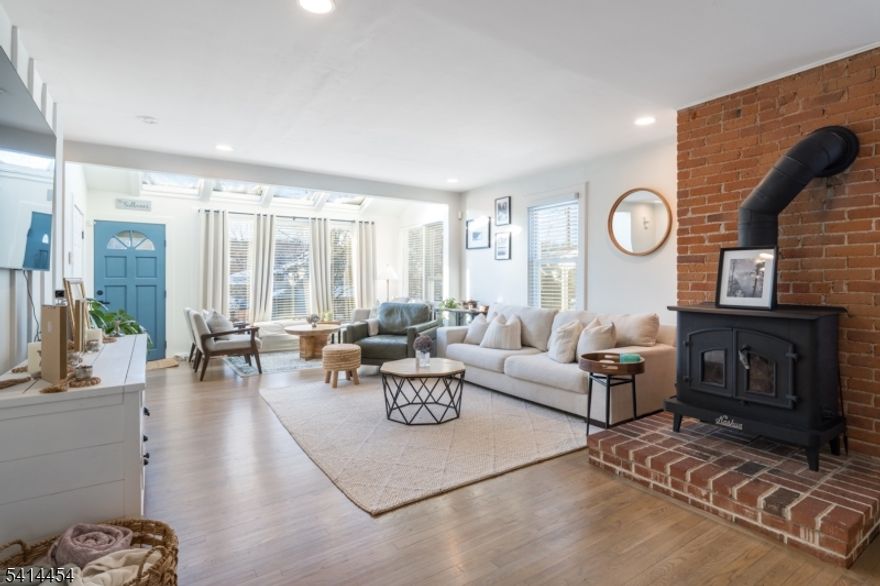 Exquisitely updated and tastefully designed, this two-bedroom in-town home is not to be missed. The bright and open main level offers flexible yet distinct living areas. The entry foyer with oversized coat closet adjoins a cozy and bright sitting area with high-ceilings and tons of windows. The main living room is anchored by a large wood-burning fireplace with exposed brick. The spacious dining area is connected to the kitchen by one of two breakfast bars. The kitchen with granite countertop, travertine backsplash and floors, offers stainless appliances, high ceilings with skylight and easy access to the rear deck. A powder room off the living room completes the space. Upstairs is a massive, 20x12 primary bedroom (currently used as a toddler's room / play space). The designer space offers a custom feature wall and shelving as well as a large barn door to the huge walk-in closet with custom shelving. The fully renovated main bathroom offers exposed brick, a shower / tub with herringbone subway tile and niche, and gold fixtures as well as lots of storage with built-in shelving and large vanity. The bright and spacious third-floor bedroom offers double closets, skylights, more exposed brick and a tasteful ceiling fan and light. The basement provides tons of storages and opportunites for a home gym or rec space. Outside is a detached one-car garage and deck. Steps from town and Whole Foods this updated gem will not last.