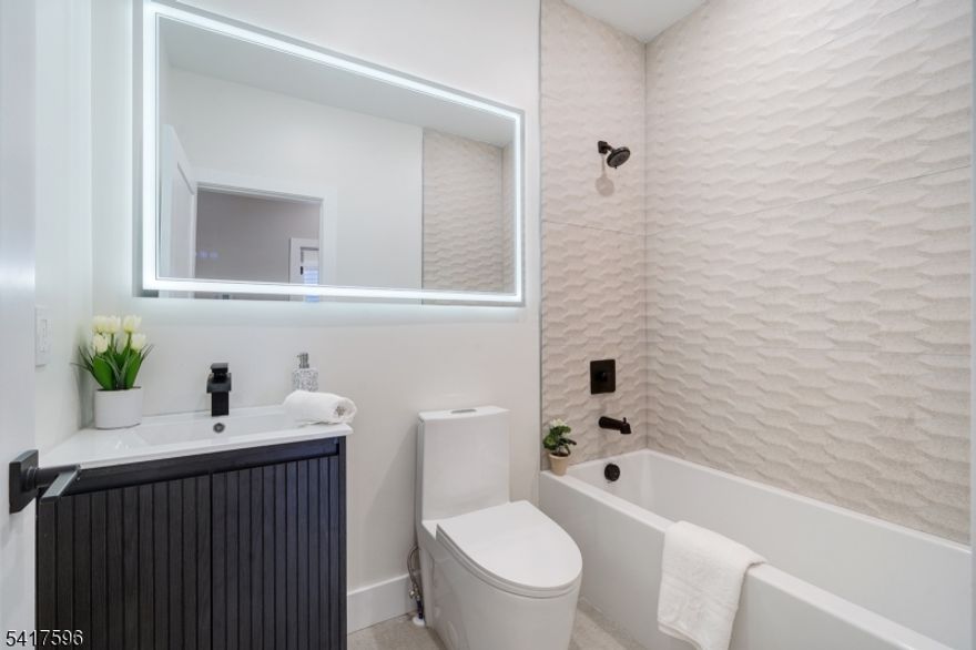 A statement of sophistication and craftsmanship, this custom new-construction two-family residence redefines modern living in Irvington, NJ. Designed with an emphasis on natural light, open flow, and contemporary elegance, every element of this home exudes refinement. From the 9-foot ceilings and gleaming hardwood floors to the European windows and designer tile-work, each detail has been curated for comfort and style. The chef's kitchen showcases quartz countertops, premium stainless-steel appliances, and a stunning center island perfect for entertaining. Step into the primary suite complete with a walk-in closet and spa-inspired bath. The versatile lower level provides ample additional living space, ideally for recreational room, media room, yoga room the options are endless, additional half bath, laundry, and access to an oversized garage. All this at a value that is truly unmatched in today's market. Incredibly low taxes and 5 year benefits apply. Conveniently located close to parks, shops, eateries, NYC commute, & so much MORE!