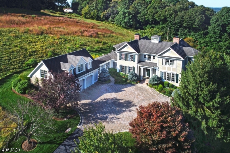 Colonial with five en-suite bedrooms, perched on stunning, private grounds with custom patios and landscape design. Expansive kitchen, walkout finished lower level with in-law suite.  ROOM FOR A POOL! Stately colonial absorbs skyline views. A soaring atrium opens to living and dining rooms, each with fireplaces, along with a music room and library. The front to back kitchen and open concept family room with fireplace, is an oasis for gathering and entertaining, with two islands and a butler pantry connected to the dining room. The mud room hall includes a half bath, while a formal powder room in the foyer rounds out the first floor. Primary suite features spa bath, walk in closet and sitting room. Three additional bedroom suites and laundry complete this level.  TAX APPEAL GRANTED Please ask for detais.