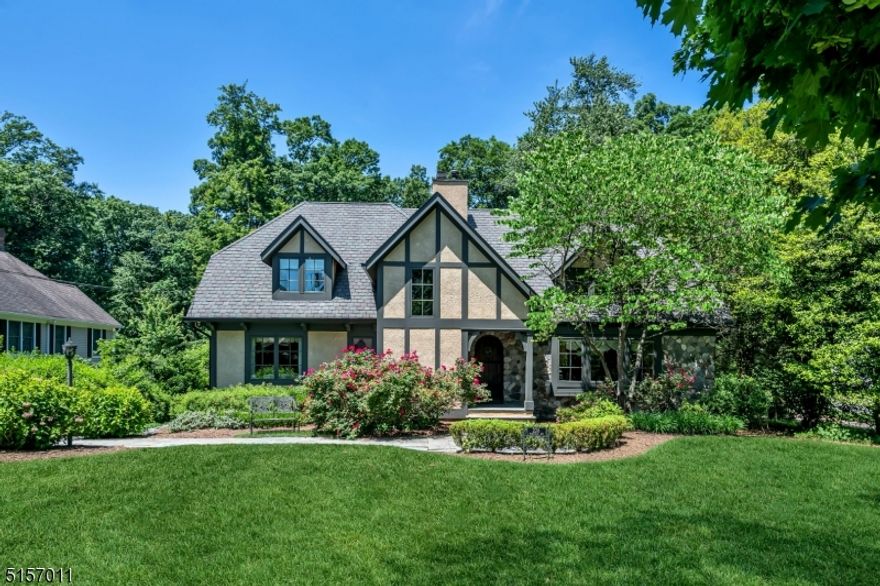 Perfectly perched on a gorgeous 3/4 acre lot on one of the most desirable streets in town, this custom country manor exudes warmth and exquisite craftsmanship. No detail was overlooked in the 2006 planning and building of this home, from the flexible open floor plan, to the window placement that captures maximum sunlight, to the quality woodwork and moldings throughout. Striking features include the banquet size dining room with two-story vaulted ceiling with wood beams, and an adjacent butler's pantry with bar area and walk-in closet; and a breathtaking gourmet kitchen, complete with a 12' island, luxury appliances, and French doors opening to a spacious deck. The primary bedroom is the perfect retreat, with its private balcony, walk-in closets, spa bath, and beverage bar. The 323' deep property has an amazing privacy buffer and stunning views in all seasons. A rare opportunity to balance prime location, newer construction, and unique charm!