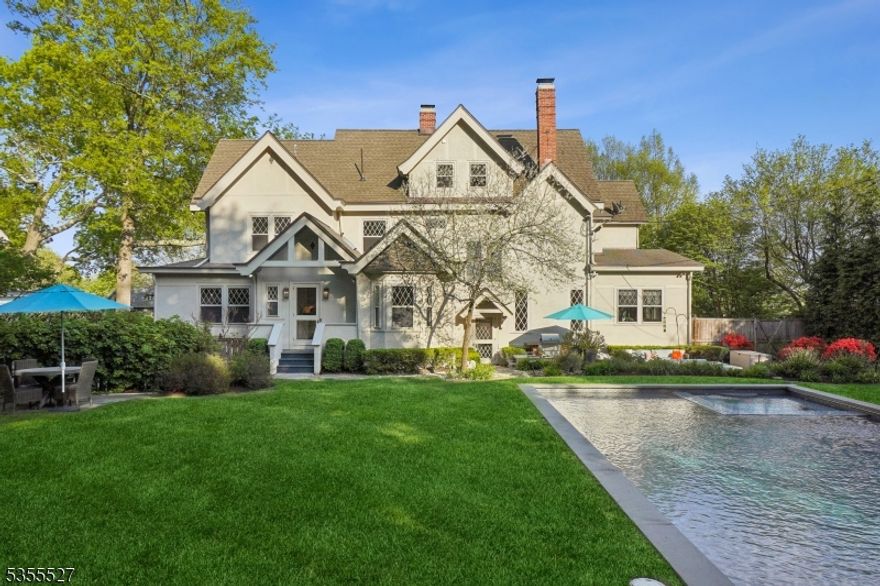 A one-of-a-kind Queen Anne estate blending old-world charm with quiet luxury, just one block from Upper Montclair's train, restaurants, shops, and parks. From the enchanting front porch to the diamond-paned and leaded glass windows, this home is rich with architectural detail. Inside, elegant moldings and gorgeous wood floors frame gracious living spaces, including a sunken living room with gas fireplace, a library with private porch access, and a formal dining room with fireplace. The chef's kitchen is a dream - custom cabinetry, professional appliances, and a large island flows into a playroom and then sun-filled fmly room. The serene primary suite features a spa-inspired bath, dressing room, and dual walk-in closets. Two additional bedrooms on the second floor, one is ensuite; the third floor offers two more bedrooms and a full bath. The finished lower level includes a screening room, wine cellar, rec room, and full bath. Something for everyone all weekend! Outside, enjoy a private resort-style retreat: Waterworks-tiled pool and spa, lily pond, waterfall patio, and lush perennial gardens. With radiant heat, 5-zone HVAC, generator, and whole-home audio this is luxury living at its most livable.