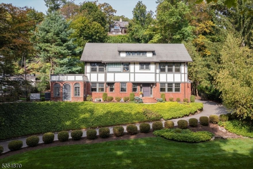 Wow! Timeless architecture meets modern functionality. This sprawling 6-bedroom, 5-bathroom home, perched to capture seasonal views of the Manhattan skyline, is a rare blend of elegance and ease, made for living well and entertaining beautifully. The main level offers a gracious layout with elevated finishes, natural light, and room to breathe. It's grand but not overdone, elegant yet livable. At the heart of the home, a chef-inspired eat-in kitchen stuns with high-end finishes, sleek cabinetry, and seamless flow to the outdoor patio. Just beyond, your resort-style retreat awaits: a built-in gunite pool, perfect for summer nights, weekend gatherings, or a quiet morning coffee with a view. The sunny, serene primary suite upstairs features expansive walk-in closets and a spa-level bath that delivers an authentic retreat experience. The additional second-floor laundry keeps your day-to-day convenience, while the sun-drenched family room and stylish home office offer flexible space for how we live now, whether you're hosting, hybrid working, or just relaxing. The multi-functional finished basement offers a rec space, fitness room, second laundry area, and a fantastic media room ready for your home theater a four-car garage, prepared to house vehicles, and extra storage space round out the package.A rare opportunity for those who want city energy with suburban space, curated design with modern ease, and room to grow in a home that reflects their lifestyle.