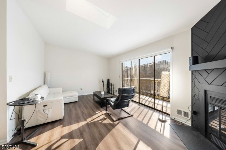 This stylish renovated end unit condo seamlessly blends modern open-concept luxury with everyday comfort. The Living Room is a true highlight featuring soaring cathedral ceilings, a stunning skylight, a wood-burning fireplace & a sliding door that leads to a private deck (soon to be replaced by HOA). The modern kitchen features custom cabinetry, pristine new countertops, a contemporary sink & a full suite of appliances, including a microwave, refrigerator, gas range, & dishwasher. New flooring, fresh paint, storage galore & updated lighting enhance the space throughout. Main Bedroom offers a walk-in closet, an additional closet, & a new sliding door. Second bedroom also offers ample closet space! The updated bathroom is equipped with a new vanity, modern medicine cabinet & new toilet. Laundry Room comes complete with new washer & dryer, plus additional storage for added convenience with additional updates including a new Central-Air unit. Abundant natural light flows throughout, making this home truly move-in ready. Take advantage of the Community Amenities: Clubhouse, Outdoor Pool, Tennis Court, Dog Run & Basketball Court. HOA covers common areas, sewer, trash, and snow removal. Exciting upgrades are underway, with the association replacing the wood siding with vinyl & enhancing/replacing the balcony decks. This unit offers the perfect blend of chic, sleek community living, modern upgrades & exceptional community amenities.