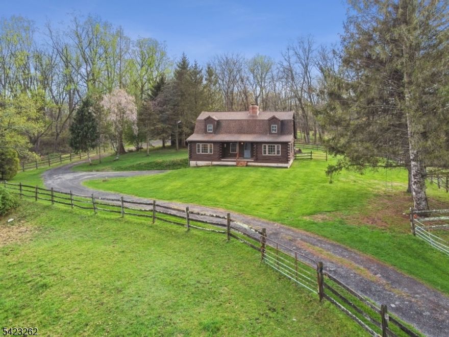Dreaming of a country lifestyle home with privacy and serenity? Stunning log cabin designed for today's easy living on 7 farm-assessed acres with sweeping views of the countryside from your front porch. A bedroom and bath on each level, a loft/office overlooking the open-beamed Great Room, main level laundry, two car garage. Full dry walk-out lower level ready to finish to your liking. Three-bedroom septic offers potential to convert loft to third bedroom. Energy-efficient heating design uses oil or coal with the flip of a switch. Wood stove adds charm and warmth to Great Room on chilly nights. Plant a garden, listen to the birds, sip your coffee or cocktails on the porch with a view of rolling fenced green pastures. Many possible uses for barn: currently five stalls for your horses, hay storage, plus machine shed for your tractor. Idyllic Warren County setting near the Delaware River with wineries, farmstands and outdoor recreation - yet only five minutes from everyday conveniences and I-80 for your commute.