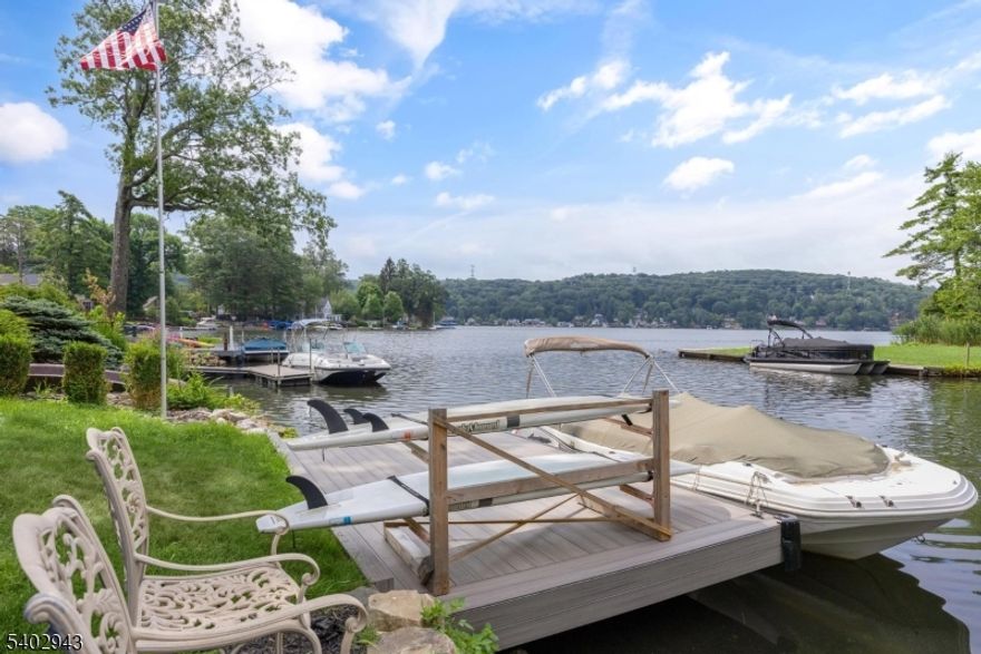 LAKE MOHAWK LAKEFRONT:  Enjoy panoramic water views and refined lakefront living in this beautifully updated mid-century raised ranch offering 2,810 sq. ft. The open-concept layout features oversized windows and sliders that flood the home with natural light and showcase year-round lake views. Sliders from the family room and two bedrooms lead directly to the rear patio overlooking the water.The designer kitchen blends style and function with professional-grade Bertazzoni refrigerator, freezer, range, dishwasher, and microwave, custom cabinetry, a marble quartzite island, and leathered marble countertops perfect for gatherings. Your private waterfront oasis includes a year-round Tidalift swim spa, stone wood-burning fireplace with seating area, lounge deck with built-in curved stone seating and fire pit space, plus a new private dock. Professionally designed perennial landscaping enhances privacy and outdoor enjoyment. The lower level offers an entry foyer, spacious recreation room, family room/home office, second wood-burning fireplace, walkout sliders to the yard, overflow fourth bedroom, laundry and utility rooms, and interior access to the oversized two-car garage. The Lake Mohawk lifestyle includes access to every beach along the lake, the boardwalk club, power boating, canoeing, paddle boarding, fishing, swimming, hiking trails and live music during season on Beach 1. Add to that the multiple golf courses, tennis clubs there are endless possibilities.