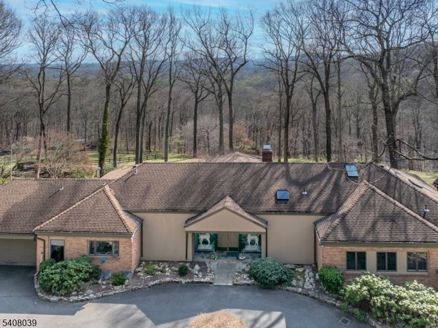 Extraordinary custom home with stunning long countryside views to the south.  Sophisticated country living yet convenient to Morristown, public and private schools, golf courses, equestrian facilities, public transportation, The Mall at Short Hills, fine dining, Newark Liberty International Airport, Jockey Hollow National Park, the New Jersey Audubon Society park and more.  The primary residence features a Living Room anchored by a wood-burning fireplace, Dining Room, paneled Library with fireplace, open-plan kitchen/sun room, luxurious primary suite with cathedral ceiling, two custom walk-in closets and a spa-like bathroom.  Two additional bedrooms and bathrooms and two powder rooms complete this level. The lower level includes a recreation room, three bedrooms, two bathrooms and storage and utility rooms. There is a three-car attached garage. The blue stone terrace invites outdoor dining and relation. A pool and tennis court provide exercise and relaxation too. Flowering trees and shrubs and perennials highlight the grounds. Solar panels provide electricity. The Carriage House, situated on a separate lot, has three bedrooms, living room with cathedral ceiling and a finished walk-out lower level. The deck provides long countryside views.