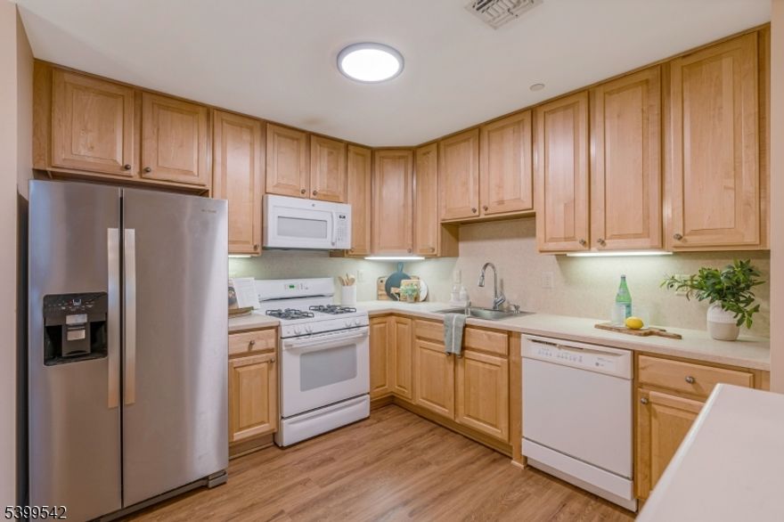 Just 30 miles outside of NYC, in the desirable gated community of Cambridge Heights, this home offers the lifestyle you have been waiting for with comfort, convenience and community all in one place. Spanning nearly 1500 sq. ft of open concept living, this multi level unit features elevator access and thoughtful updates throughout.The welcoming foyer introduces the flow of the home and leads into the main living spaces. At the heart of the main level, the kitchen offers 42  cabinets, ample storage and new stainless refrigerator. It opens to the dining room where chair rail and crown molding add charm and create an inviting space. The living room unfolds with vaulted ceilings and stone accented gas fireplace. Sliding doors lead to a private balcony, while new luxury plank flooring and custom blinds bring it all together with warmth and style.Tucked off the living room, the primary suite is appointed with a tray ceiling, walk-in closet and updated ensuite bath. Completing the main level is a second bedroom, hall bath and laundry room with a new washer and dryer. Elevating the home's versatility is a second floor loft with walk-in closet, it easily serves as a den, a 3rd bedroom or flex space to suit your lifestyle. The newer hvac and water heater adds peace of mind. Residents of Cambridge Heights enjoy plenty of parking, an outdoor pool, fitness room and clubhouse for gatherings, all within a peaceful setting that remains close to major highways, shopping and restaurants.