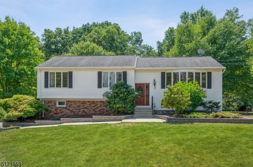 Spacious & secluded on an oversized lot! Move-in ready Bi-Level home 4Bd, 2 1/2Bth & an attached 2-car garage is situated on nearly an acre of manicured property on a quiet cul-de-sac. Offering peaceful privacy in a bucolic setting, this home is close to stores and eateries with quick access to Rt 287, 78 & 22. Beyond the sweeping front lawn, the entryway opens to a sun-filled main level with hardwood floors and great natural light from the huge bow window in the living room and the adjoining dining room. The open flow continues into the light and bright kitchen with granite counters, stainless steel appliances, and warm cabinetry topped with custom crown molding. From the dining room, step outside to a beautiful deck overlooking the expansive back yard with mature shade trees, a patio, a dog run, a large storage shed, and plentiful space for gardening and relaxing. The bedroom wing includes a primary suite with a walk-in closet and full private bathroom, two additional bedrooms, and a full bathroom in the hallway. Additional living space on the ground level includes a large family room with a wood-burning stove and glass sliders to the patio. There also a half bathroom, a fourth bedroom, a workshop, and laundry room. Two stairways from the family room take you to either the front entrance or the kitchen. This spacious, sun-filled home offers comfortable everyday living and entertaining spaces and an exceptional amount of private, beautifully tended outdoor space.