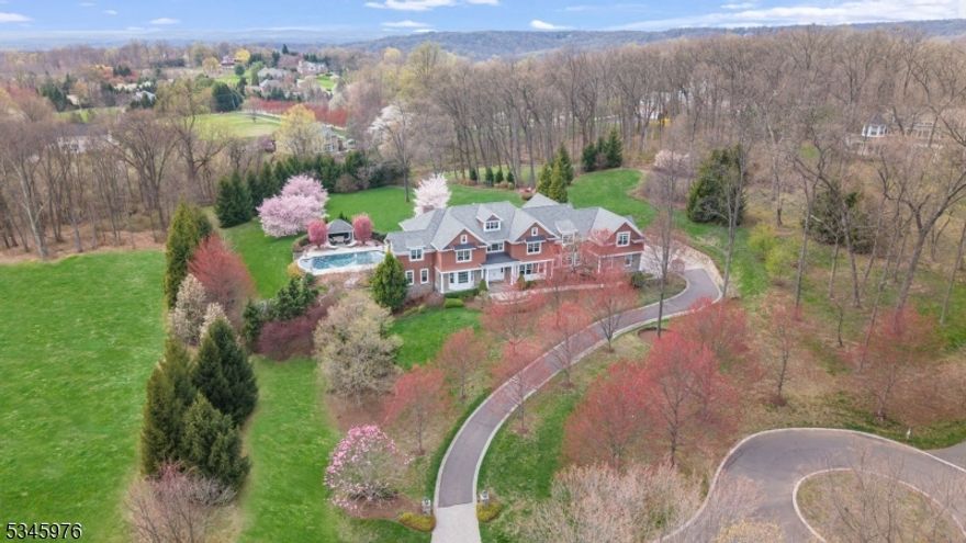 Poised on a prime 3-acre cul-de-sac, this Hampton inspired 9000+ SF manor and resplendent resort-style grounds, blend classic sophistication, relaxed living and outstanding contemporary luxury. Hampton charm exudes from notable gables, the stone and cedar shingle siding, columned portico. Interior rooms grandly display exquisite architectural detailing, high ceilings, oak floors, expansive windows. Formal rooms w/ tray ceilings. Gourmet kitchen presents custom cabinetry, 8.5-ft centered island, granite countertop, top-of-the line appliances. Breakfast rm, Family rm & cherry wood Office each w/ fpls. Six en suite bedrooms including one on main level. Primary Suite w/ luxurious sitting rm, fpl , dressing room with multiple closets including 2 custom walk-ins. Spa-like bath boasts marble finishes, jetted tub, steam shower. Four additional en suite BRs each with custom walk-in closets. Laundry Room and yet more storage. Stairwell access to attic. Walk-out Lower-Level hosts Recreation/Game rm, bar, state-of- the-art Theater, Exercise Rm. A Cabana with changing area & full bath complements the outdoor living experience. Beautifully integrated with the topography of the land are saltwater pool, spa, waterfall, stone patio w/fpl, kitchen, pergola covered dining area, firepit. Lush landscaping provides natural privacy. Two, 2-bay garages plus lift. Cutting edge utilities and mechanical systems. A luxurious retreat for discerning homeowners seeking the ultimate in comfort and style.