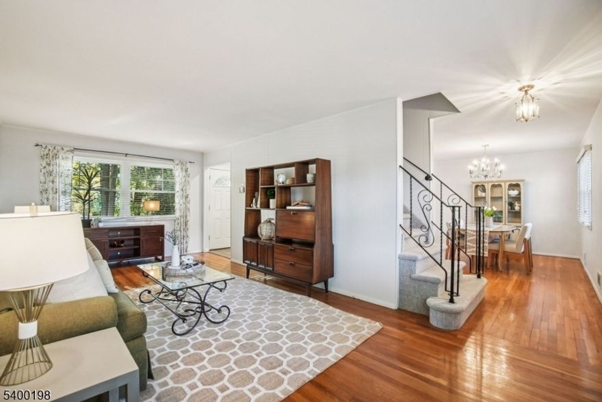 Welcome home to this charming 4 bed, 1.5 bath Colonial in the desirable Oak View neighborhood of Bloomfield. The first floor boasts a bright living room, formal dining, and a sparkling white eat-in kitchen with stainless steel appliances, pale granite, and white oak flooring. A convenient powder room is also on this level. Enjoy beautiful hardwood floors in the living and dining rooms, newer thermal windows, recessed lighting, central air, and excellent closet space throughout. Upstairs, you'll find four spacious bedrooms and a full bath with a tub shower. The finished basement offers a fantastic bonus area perfect for a playroom or rec room. Head outside to a beautifully landscaped backyard with a spacious patio and mature trees, creating a peaceful, private oasis. A one-car attached garage and a wide driveway with space for two more cars complete this perfect picture. Plus, you're just moments away from shopping, major highways, and NYC transportation.