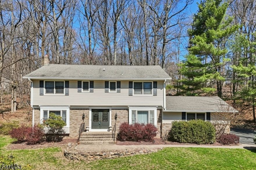 Welcome home to this beautifully maintained Center Hall Colonial in the highly sought-after Powder Mill Estates Section of Parsippany. As you enter the neighborhood, you'll be greeted by sun-filled winding roads, well-manicured properties, and generously sized lots. This spacious home offers 4BR, 2.1 baths, and sits on a .936-acre lot. Step through the front door into an inviting foyer with large French doors opening to the Formal LR. To the right, the Formal DR awaits both with gleaming HW floors. The Eat-In Kitchen features maple cabinetry, stainless steel appliances, Corian countertops, and ample pantry storage. Adjacent is a convenient Laundry/Mud Room near the 2-car garage entrance. The kitchen's dining area includes sliding glass doors to a deck overlooking the private wooded backyard perfect for entertaining. The first floor also includes a large Family Room with a cozy gas fireplace. Upstairs are four generously sized bedrooms, all with recessed lighting and large walk-in closets. The Primary Suite offers his-and-hers walk-in closets and an en-suite bath with dual sinks and a stand-up shower. Two rear bedrooms feature skylights w/ abundance of natural light. All carpeted rooms have HARDWOOD UNDERNEATH. The finished basement provides extra living space and storage. Furnace (2025) HWH (2018). Add'l features: 4-Zone Sprinkler System, Gutter Guards, Fresh Paint. Close to Routes 80, 287, 46, 10, NYC BUS/TRAIN, TOP RATED SCHOOLS, parks, shopping, dining.