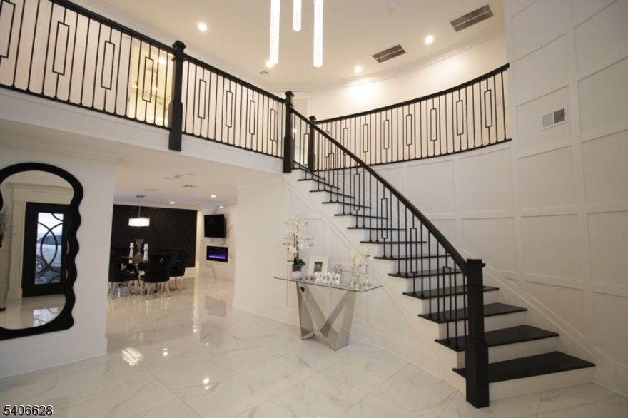 A true statement of luxury, this fully reimagined three-story Colonial at 315 Freemans Lane sits on a beautifully landscaped one-acre property in a premier neighborhood and was rebuilt in 2024. Offering 6 bedrooms and 6.5 bathrooms, the home masterfully blends timeless elegance with modern luxury. Highlights include multiple fireplaces, porcelain and ceramic flooring throughout, and a dramatic grand foyer that opens into expansive, light-filled living and entertaining spaces.The chef's kitchen is truly a showpiece, featuring an oversized island, quartz countertops, custom cabinetry, a striking brass-accented range hood, farmhouse sink, walk-in pantry, and an additional coffee/bar room ideal for entertaining. The first floor also offers a bedroom and a separate office, each adjacent to a full bathroom, providing excellent flexibility for guests, multi-generational living, or work-from-home needs.The second level is anchored by a luxurious primary suite retreat with a sitting area, an impressive two-story walk-in closet, an additional walk-in closet, and a spa-inspired bath. Two additional ensuite bedrooms and a conveniently located laundry room complete this floor.