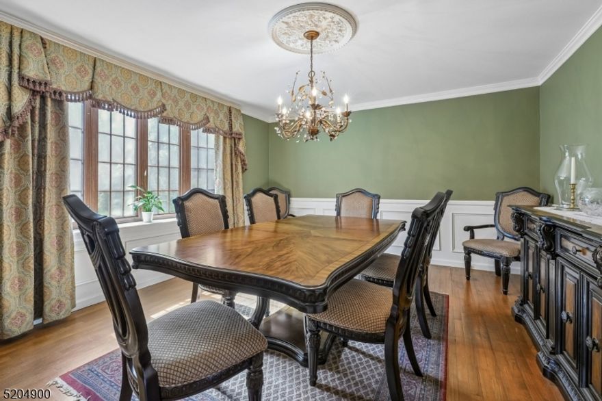 Set on a picturesque 0.81-acre property, this inviting Center Hall Colonial presents great value & a wonderful opportunity to customize and enhance its expansive 4,600 sq ft layout, perfectly suited for both everyday living & entertaining. A welcoming center foyer introduces sun-filled living & dining rooms, each accented by charming bay windows. The family room, featuring a wood-burning fireplace with stone hearth, flows seamlessly into a spacious sunroom offering excellent potential as a bright, versatile gathering space with direct access to the sweeping rear deck and deep backyard. The kitchen is thoughtfully designed with wood cabinetry, Corian countertops, a center island, stainless steel appliances, & a separate breakfast area, along with convenient deck access for effortless indoor-outdoor dining. A powder room, laundry room, & access to the attached two-car garage complete the main level. Upstairs, the primary suite features a walk-in closet and private full bath. Three additional bedrooms, each featuring walk-in closets and a full hall bath provide comfortable accommodations. The finished lower level adds exceptional flexibility, offering a recreation room, office, music studio, exercise room, full bath, and ample storage. Outdoors, the two-tiered deck and expansive yard create an ideal setting for entertaining, play, or quiet relaxation. Highly rated school system. Close to shopping, dining & parks, Approx 1.3 miles to BH Midtown Direct train service to NYC Penn.