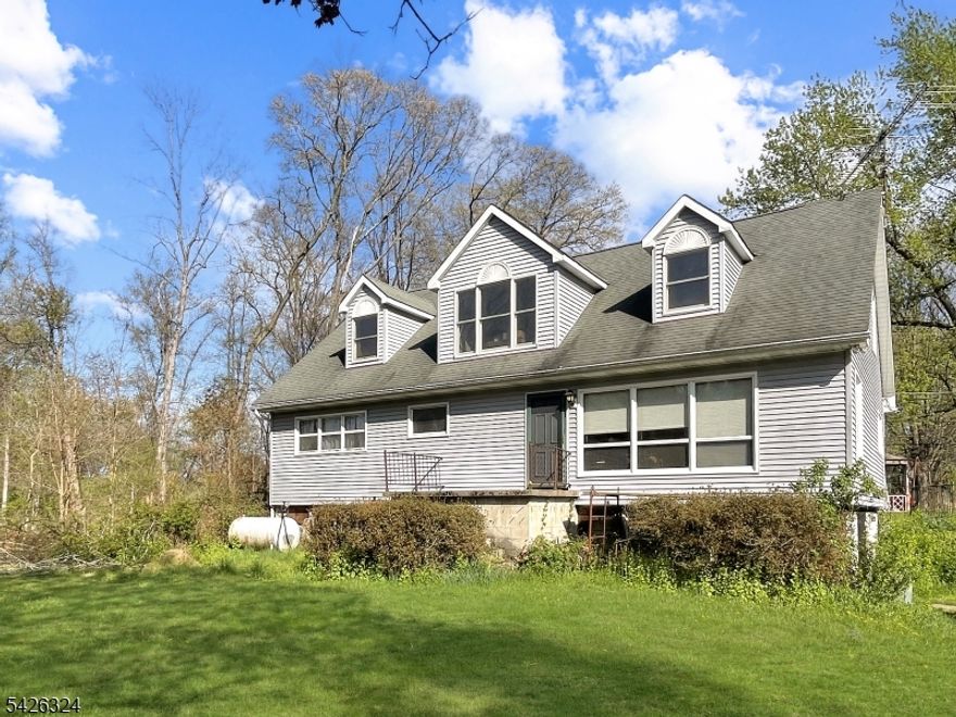 Welcome home to this charming and versatile Cape Cod, perfectly situated on over two acres of level property. Offering incredible potential, the unfinished second level provides a prime opportunity to easily expand, ideal for adding two additional bedrooms, a full bath, and extra living space to suit your needs. The main floor features a spacious kitchen, a bright and inviting living room, a formal dining room, two comfortable bedrooms, and a full bathroom. Downstairs, the expansive walkout basement offers even more possibilities, complete with a cozy wood-burning stove and direct access to the driveway. Step outside from the deck and enjoy the wide, level backyard leading to an impressive four-car garage, perfect for contractors, hobbyists, or anyone needing ample storage for larger vehicles, including trucks. Conveniently located just minutes from Route 80, this home offers an easy commute to NYC in under an hour. A rare combination of space, potential, and accessibility - don't miss your chance to make it your own!