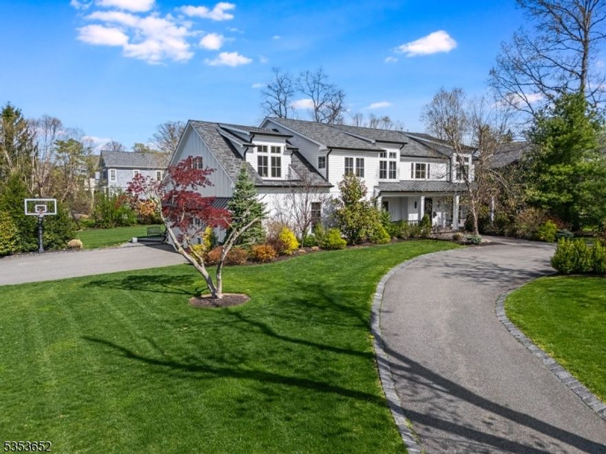 A rare offering in Livingston's prestigious Coventry neighborhood, 26 Coventry Rd redefines custom living at its finest. Completed in 2017, this 7,000+ sq ft modern farmhouse sits on .9 acres of manicured property, where thoughtful architecture meets contemporary design. A double-height foyer, white oak floors, custom lighting, and 10' ceilings on the main level create a seamless blend of scale, light, and warmth. The chef's kitchen impresses with double islands, Wolf and Sub-Zero appliances, custom concrete countertops, an oversized sink, and a sunlit breakfast area. A butler's pantry, walk-in pantry, and custom built-in workstation add functionality. The expansive family room with a gas fireplace and exposed beams opens to a covered patio, perfect for effortless indoor-outdoor living. The first floor also features an in-law suite, home gym, and mudroom with radiant floors and garage access. Upstairs, the primary wing offers a large bedroom with tray ceiling, two custom walk-in closets, a private covered porch, and a spa-quality bath with heated floors, a sculptural soaking tub, and dual full baths connected by a walk-through glass shower. Three additional bedrooms, an upstairs den, and a full laundry room offer flexibility. The walkout lower level impresses with soaring 10' ceilings, a rec room, custom bunk bed suite, 2nd kitchen/laundry, and guest bedroom. Designed for modern living with enduring style, 26 Coventry Rd delivers timeless craftsmanship and elevated comfort.