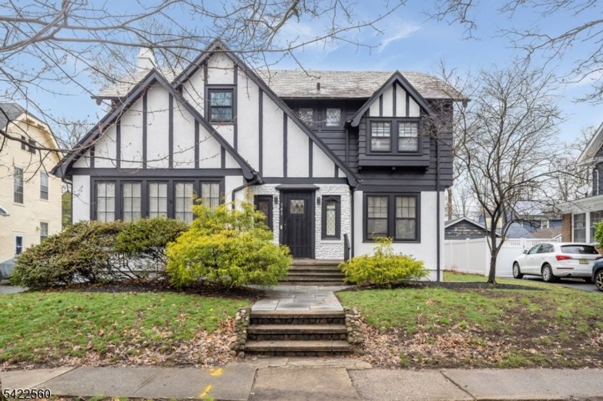 GORGEOUS TURNKEY 4 BED/2.1 BATH HOME IN HISTORIC TUXEDO PARK BLOCKS FROM SETON HALL! This 1920s Tudor Revival immediately impresses with stunning black & white exterior dressed in leaded glass windows, stone fa ade & timber accents right out of a fairy tale. Discover the best of both worlds inside with charming historic details like inlaid original hardwood floors, archways, wrought iron hardware, oversized casement windows & beautiful built-ins like the wood phone cabinet in the Foyer & arched glass door bookcases in the sunny Living Room. Timeless details perfectly blend with modern updates to create an exceptional home in both function and style. Expansive Family Room with wood-burning fireplace is bathed in light from front to back. Formal Dining Room leads into fully updated Eat-in Kitchen that's a dream for every home chef with tons of cabinetry space, gleaming quartz countertops, professional SS appliances & inviting breakfast nook framed by original casement windows. Sleek Mudroom/Laundry Room are just off Kitchen along with Powder Room for the ultimate convenience. Upstairs features 4 great-sized Bedrooms & 2 modernized Bathrooms, including Primary Ensuite which has windows on 3 sides, 2 closets & a window seat. Third Level is an amazing, finished bonus space perfect for a Rec, Exercise or Craft Room! Lower Level is unfinished, clean & dry. Welcoming backyard has flowering shade trees & paver stone patio for al fresco dining. Move right into this Tuxedo Park beauty!
