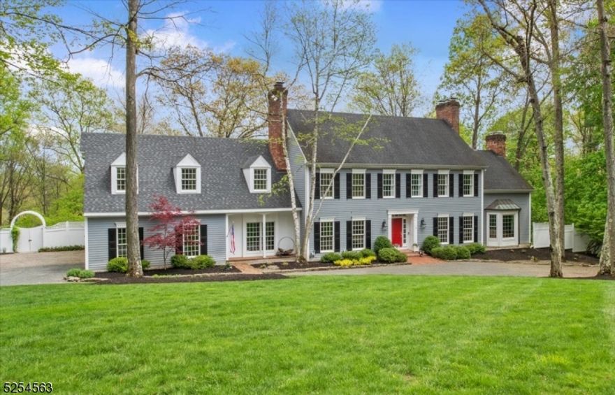 Gracious, custom-built Williamsburg style colonial situated on over two lush, private acres in highly desirable Peapack-Gladstone. The home's inviting exterior hints at the delightful living areas with exceptionally large interior rooms and a show-stopping backyard with pool that will both surprise and delight. The first floor includes a gorgeous cherry library, a bright, airy, custom kitchen with high-end appliances and light-filled living and family rooms with floor to ceiling windows. French doors lead to a curved terrace for coffee or cocktails, conveniently prepared at your wet bar. Settle in for a cozy meal in the one-of-a-kind Keeping Room, enjoying one of the home's eight fireplaces. Connectivity and security are assured with a standby generator hidden just outside the work-paneled, three car garage. Upstairs, four bedrooms plus two large office/flex spaces with closets include a front to back main bedroom, large main bath, and two enormous closets that must be seen to be believed! The lower level features an additional 1,300 sq/ft of beautifully finished walk out space, including media and billiard rooms, a wine room, and yet another flex space complete with full bath and French door access to the backyard. Two levels of curving bluestone paths lead to the breathtaking rock formed pool, featuring a waterfall and integrated hot tub. mature landscaping with thoughtful design ensures this home is a haven from the inside out.