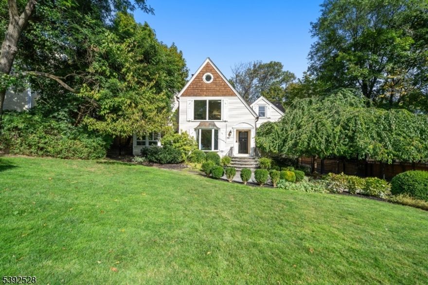 Welcome to 70 Llewellyn Road, an elegant retreat on one of Montclair's most coveted streets. This custom residence blends sophistication and comfort, offering privacy and tranquility just moments from downtown shops, dining, parks, and NYC transportation. Step inside to discover beautifully designed living spaces perfect for entertaining or everyday living. The first floor unfolds with a gracious living room featuring recessed lighting and a wood-burning fireplace, opening to a sunlit sitting area that invites relaxation. The expansive family room flows into a chef's kitchen with stainless steel appliances, Thermador gas range, center island, two dishwashers, wet bar, and wine fridge all overlooking a private patio ideal for gatherings. A formal dining room, large office, and first-floor bedroom suite with a private bath complete this level with elegance and versatility. Upstairs, the serene primary suite offers a luxurious escape with a skylight, sitting area, walk-in closet, and spa-like bath with soaking bubble tub and glass-enclosed shower. Three additional bedrooms, a full bath, laundry, and a cozy landing with custom built-ins complete the upper level. The finished walk-out basement includes a recreation room, mudroom, powder room, laundry, and direct garage access. Outside, enjoy a deep backyard with privacy fencing, expansive paver patio, and wide driveway for guests. Move right in and experience Montclair living at its finest.