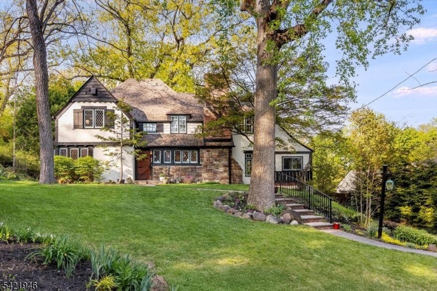 With unmatched storybook curb appeal, it's the warmth, character, and feeling of home that make this 4 bdrm, 3 bath Maplewood gem truly unforgettable! Set on a picturesque, tree-lined street with deep lots and layered landscaping, this neighborhood is serene yet only .7 mi to town. Stepping in, there's a welcoming energy that instantly makes it feel like home. The sunken living room is dramatic and inviting, centered around an incredible stone fireplace and framed by windows that fill the space with light. Throughout the home, original details have been preserved & celebrated, including leaded glass casement windows - casting the most beautiful light and a sense of history and charm. A den provides the perfect secondary living space, while a 1st floor bedroom sits beside a truly special full bath - ideal for guests or a work-from-home retreat. The custom kitchen with high-end, design-forward finishes feels elevated, and perfectly in tune with the home's architecture. The bedrooms are incredibly generous, offering room to grow, and the primary bath delivers a spa-like experience. The finished basement is a perfect place to hang or play. Outside, the landscaping and backyard create a private, idyllic escape perfect for morning coffee & dinners. Just a short stroll to Maplewood Village, with its beloved shops, restaurants, & NYC train, this location offers the best of all worlds! A home filled with soul, beauty, and tranquility - a truly special place to call home!