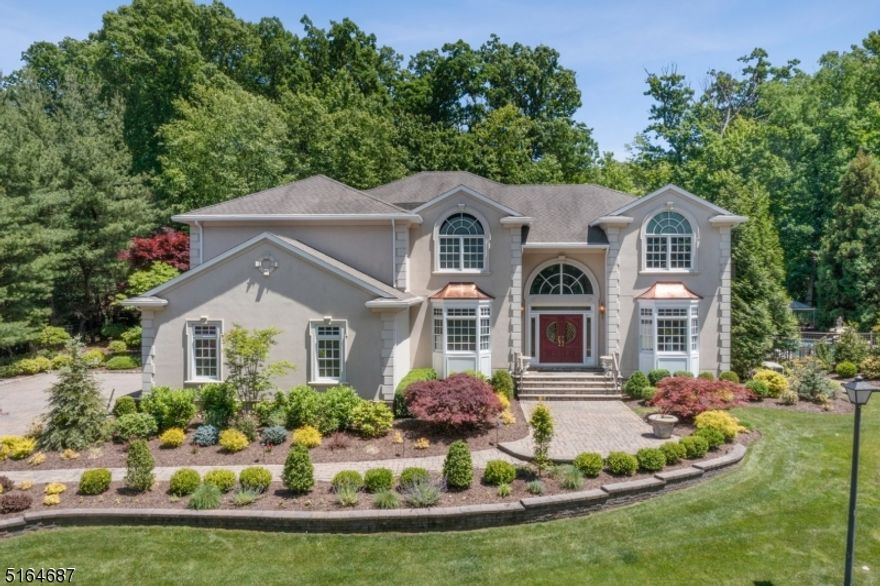 Spectacular custom home offers exceptionally large entertaining spaces, inside and out. Park-like, the very private property is perfectly set on a rise in the prestigious North Caldwell neighborhood. Dramatic two-story entry foyer with curving staircase to a second-floor balcony. Great Room is the heart of the home, with two-story Palladian windows, a wet bar, hardwood floors, a stunning fireplace, 3 French doors & built-in media center. The huge chef's kitchen has an eat-in area that seats 10 with 3 skylights above. 2 French Doors (out to patios) and 6 floor-to-ceiling windows flood the room with light.  Island with double sink and breakfast bar seating for 5. Top-of-the-line appliances include a new (2022) Miele dishwasher, 6-burner Thermador stove w/grill, and double Thermador wall ovens. Formal DR with w/built-in cabinetry flows to charming LR w/ mullioned bay windows. Office off Center Hall is ideal for WFH, w/smoked glass French Doors. 2nd flr includes a fabulous Primary Suite w/sitting room, separate bedroom w/coffered ceiling & Palladian window, and luxurious spa-like bath. three add' bedrooms, two full baths also on this level. Incredibly spacious lower level features game rooms, exercise rooms, playroom, wet bar, media area, and more. Don't miss the outdoor delights including paver patios, built-in grill area, freeform heated, saltwater pool w/spa, and waterfall: summer will never be the same! 3-car heated garage with car lift and radiant heat floors throughout.