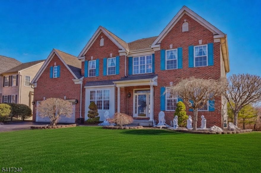 Welcome to this stunning 5300 sq ft open floor plan including finished walk-out ground level 4-bedroom, 3.5-bath Colonial. Sitting on the outer circle of highly sought after Water's Edge with open space front and back views of wood.  Beautifully landscaped grounds and flowering trees create exceptional curb appeal. Inside, a grand two-story foyer with a curved staircase opens to formal living and dining room, a private office, and a dramatic two-story family room with transom windows and a gas fireplace. The eat-in kitchen features custom cabinetry, a walk-in pantry, a 10' granite center island, stainless steel double ovens, commercial-grade hood, built-in gas cooktop, and a second staircase to the upper level. Enjoy a bright breakfast area and sunroom overlooking peaceful wooded views with access to a spacious two-level deck. The primary suite offers a sitting room, luxurious bath, and two walk-in closets plus 3 additional spacious bedrooms. A finished daylight walkout basement includes a guest room, second office, dining room, and storage/gym space. Wait, there's more features including 52 prepaid Tesla solar panels to power your home. Step outside on ground level is the extensive paver/patio basketball court for your recreational and entertaining fun with outdoor lighting. All proximity to both Round Valley, Spruce Run and Columbia Trail. Easy access to NYC/Philadelphia commute.