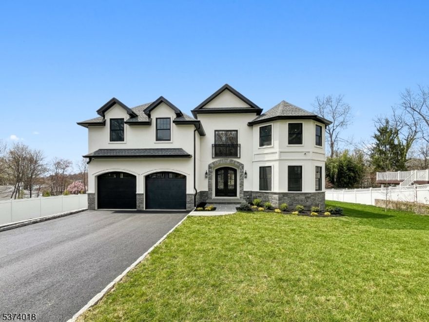 Discover timeless elegance in this brand new custom-built home in desirable Packanack Lake, featuring 5 spacious bedrooms and 4.5 beautifully designed bathrooms. From the grand two-story foyer to the detailed finishes throughout, every space reflects quality craftsmanship. The chef's kitchen showcases custom cabinetry, quartz countertops, a striking backsplash, high-end appliances, a pantry, and a separate butler's pantry with wine fridge and storage. A formal dining room and inviting living room provides an ideal setting for entertaining. The great room which is open to the kitchen and casual dining area, offers a warm and welcoming space with a fireplace, coffered ceiling, and access to the deck and yard for seamless indoor-outdoor living.  A first-floor bedroom with private en suite is ideal for guests or a home office. The mudroom off of the garage adds function and organization to everyday living. Upstairs, the luxurious primary suite features vaulted ceilings, a fireplace, oversized walk-in closet, and spa-like bath with soaking tub and large glass shower. A second en suite, two additional bedrooms with Jack & Jill bath, laundry room, and a walk-in attic complete the upper level. The expansive basement includes rough plumbing for a future bath.This smart home features the latest in modern living including built-in speakers, EV charger and central vacuum making it the perfect blend of timeless craftsmanship and today's luxury living.