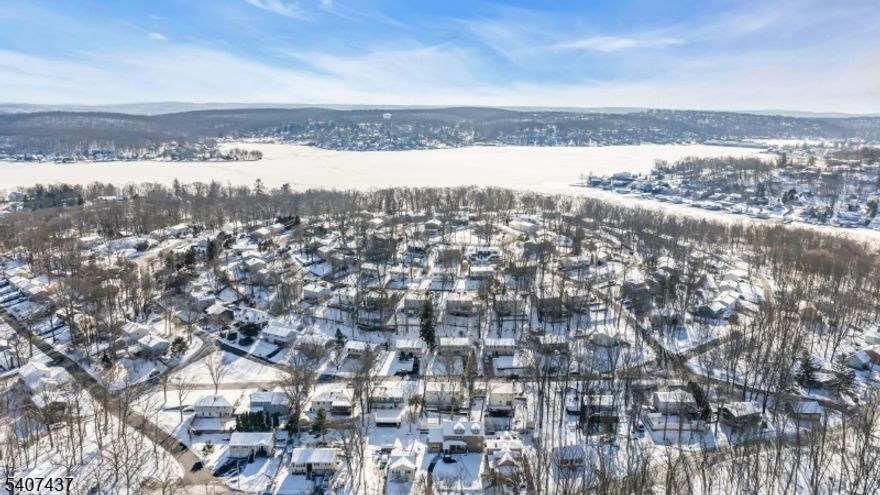 Welcome home to this well maintained two-story residence offering space, warmth, and versatility in a highly convenient location. The main living level features hardwood flooring beneath the carpet and a warm, welcoming foyer accented by classic parquet wood floors. An open floor plan flows effortlessly from the living room into the dining area, which opens to an inviting eat-in kitchen with timeless oak cabinetry ideal for everyday living and entertaining.Three generously sized bedrooms and a full bath complete the main level. The walk-out lower level expands your living space with a light filled family room and a private fourth bedroom with an en-suite bath perfect for guests, extended living, or a home office. Step outside to a sprawling 30-foot deck designed for entertaining, with stairs leading to a level backyard play area and storage shed. Located in the Elba Point community, optional beach club membership includes access to a clubhouse, beach, and dock slips, and all within walking distance. Enjoy quick access to downtown shops and restaurants, NJ Transit train and bus service, and major commuting routes. Notable updates include a newer roof, furnace, hot water heater, and keyless garage entry. Surrounded by nearby hiking trails, parks, and recreation, and less than 30 minutes to a premier ski and golf resort this home truly offers the best of comfort, lifestyle, and location. Note: 3 bedroom septic