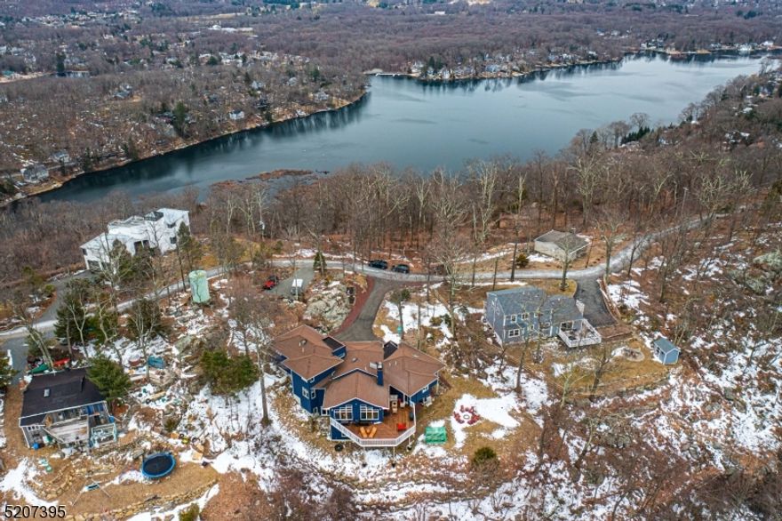 Impeccable Custom Contemporary w/stunning Mountain views surrounded by Jonathan's Woods which includes 635 protected green acres & hiking trails. Truly an oasis of peace & privacy located in the Cedar Lake section of Denville -truly unique & architecturally captivating home. 13 rooms across 5000 plus sqft of sophisticated living. professional designed w/ feng-shui philosophy in mind. Open, main living areas w/ 15' vaulted ceilings include a towering natural stone fireplace, wall of windows, striking modern-design chef's kitchen w/ new appliances, formal dining & family room. Imported HW & tile flooring throughout. 1st floor, cloistered primary bdrm suite replete w/ private office, multiple closet spaces & exquisite primary bath. Upstairs, 2 generous sized bdrms & full bath. Sprawling lower level has expansive entertainment, recreation, workshop, exercise area & full bath.  Wheelchair accessible w/elevator. An abundance of windows throughout provide a beautiful ambience, tons of natural light & stunning views from every corner. The oversized back deck is a priceless addition to this home -sunset views from the back & lake/skyline views from the driveway. Oversized 2-car garage w/ tons of parking. Picturesque wooded setting on quiet, dead end street. Experience tranquility, luxury & privacy right in your own backyard w/all the conveniences of NYC mass transit, easy access to major hwys, DWTN Denville.