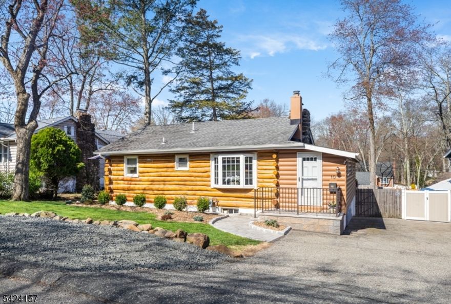 AMENITY-FILLED LAKESIDE LIVING WITHIN 25 MILES OF MIDTOWN NYC! You can have it all in the beautiful Packanack Lake residential community in Wayne: 2 beaches, clubhouse, golf, tennis, fishing, boating & a year-round calendar of activities & social events! All this just one block away from a charming log cabin/bungalow tucked into a serene neighborhood. Spacious in feel despite its size & loaded with historic details, day to day living is stress-free with modern renovations. Living Room with bright bay window & original stone wood-burning fireplace centered on exposed log wall is the heart of the home where many happy gatherings will unfold. Dining Room accommodates table & has sliders to new wood deck with plenty of room for grill/outdoor table making dining a joy no matter the season. Newer completely renovated Kitchen just steps away boasts white cabinetry, quartz countertops, subway tile backsplash, trendy beverage bar with gorgeous stone/wood inlay tile surround & stainless steel Kitchenaid appliances including gas range. Two cozy bedrooms shelter with wood-beamed ceilings, exposed log walls, built-ins & ample closet space, including a surprise walk-in! Full Bath has been fully updated & includes tub/shower combo. Finished walk-out Lower Level features great space for Rec Room/Office/Play or Exercise Room, Laundry Room & unfinished Workshop/Storage space. New front exterior log siding, landscaping, stoop & parking space. Your new year-round lake retreat awaits!