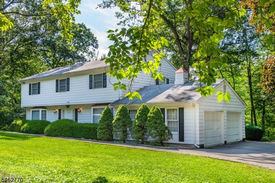 Special Find! Custom Colonial w/Circular driveway near the Rockaway RIver Country Club. Just on the border of Mountain Lakes. Gorgeous, wooded, park Like Setting, Level .95 Acre Property. Gift wrapped in Landscaping- lawn, perennials, mature trees, deck & pond just waiting to be refreshed and refilled. Many rooms to accommodate a versatile lifestyle; handsome entertaining space. Eat in kitchen w/Pantry, Mud & Laundry Rooms conveniently located off the 2 car garage. Fabulous brick WB fireplace in cozy family room- wood paneling, windows & wet bar closet. Large formal dining & living rooms bookend the foyer. Make it your own! Numerous features to fall in love with. Vintage Details, Chandeliers, Large Bay Windows. Upstairs 3 generous sized bedrooms w/large closets, bath w/double vanity plus oversized Primary w/cedar walk-in closet & en-suite. All this but still saving the best for last.. bsmt hosts a full Pub, Billiards room & large workshop. Rounded corners & wooden paneling give it that extra dose of uniqueness. All thoughtfully constructed, designed, customized & cared for by the Original Owners. Spacious & Gentile inside & out. Perfect for entertaining! Ideal location near mass transit, highways, shopping and schools. (2 car garage can be expanded to 3- the concrete pad for 3 cars was included in the original design & is adjacent to the current garage)