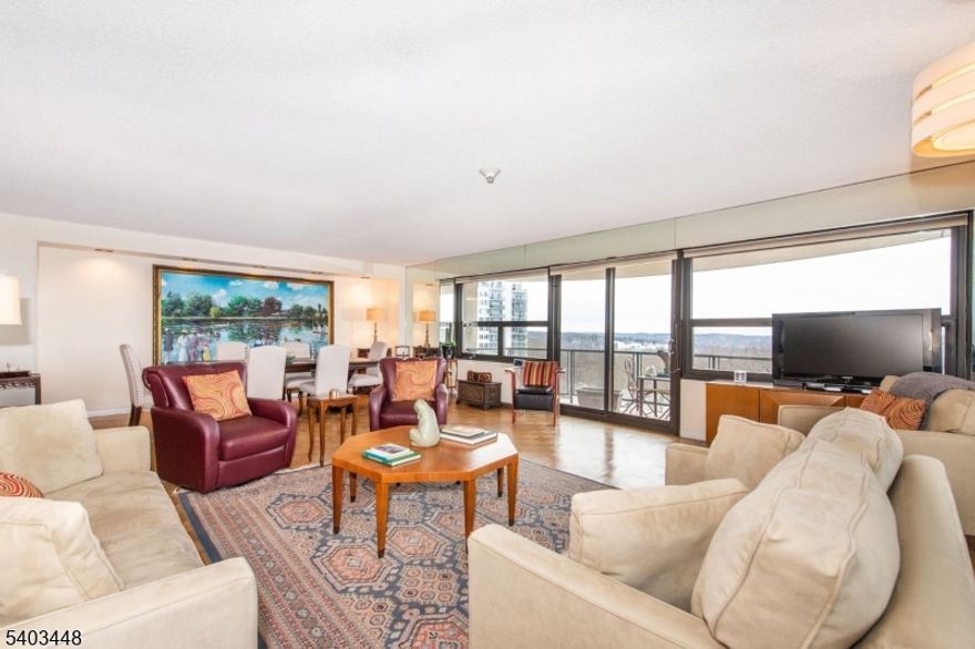 Experience refined living in this exquisite open-concept end-unit condo, filled with natural light and designed for effortless entertaining. The spacious living and dining areas feature expansive Thermopane windows and sliding doors that showcase sweeping panoramic sunset views over rolling hills and a serene, wooded landscape. Step outside to your private balcony - perfect for unwinding at day's end. The adjoining eat-in kitchen offers sleek white cabinetry, granite countertops, appliances, and the convenience of an in-unit washer and dryer. The primary suite includes two walk-in closets, a dedicated dressing area, and a private en-suite bath. A second bedroom easily adapts as a guest room, home office, or den. Recent upgrades include neutral carpeting and fresh paint. A floor-level storage unit provides additional storage. Monthly maintenance covers all utilities. Residents enjoy an exceptional suite of amenities, including 24/7 concierge and valet service, party and card rooms, a library, a full-building backup generator, a fitness center with saunas and showers, a heated Olympic-size pool, a BBQ area, a 7-cup putting green, a tennis court, and a basketball/pickleball court. Ideally located near major highways, NYC bus routes, and the Montclair train station, with shopping, dining, and parks just minutes away. A timeless yet contemporary home - make it yours today! Sale As-Is.